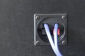 Speaker wires connected to spring loaded terminals on the back of a speaker cabinet