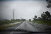 driving down an empty country road on a wet day