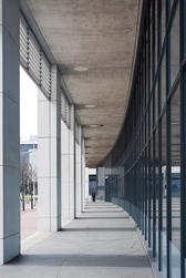 External covered passageway on a modern commercial building with a curved receding perspective in an urban environment
