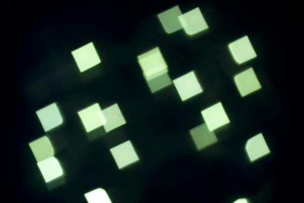 defocused camera effect, green lights create square bokeh