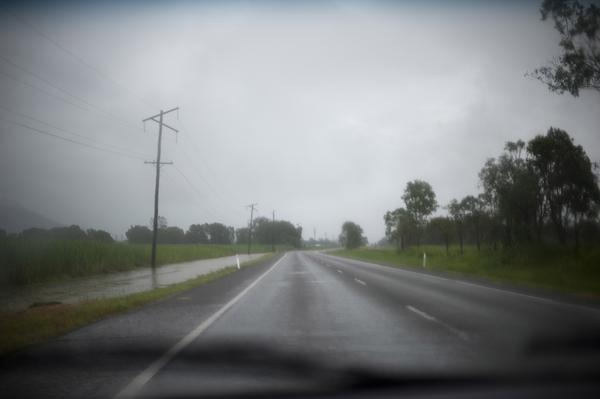 driving down an empty country road on a wet day