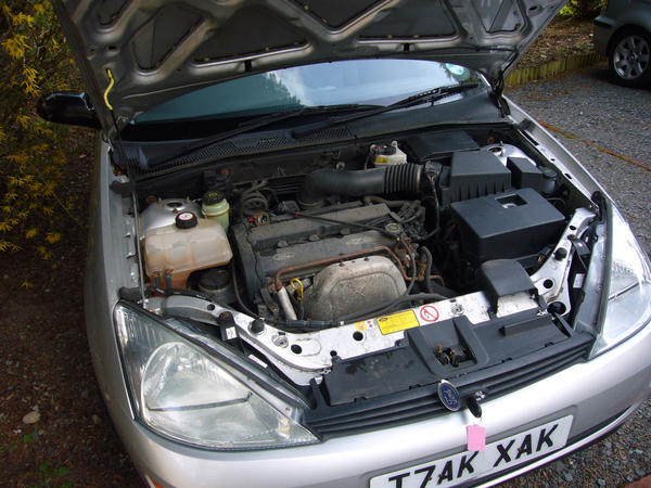a car with the bonnet open, old rusty engine components