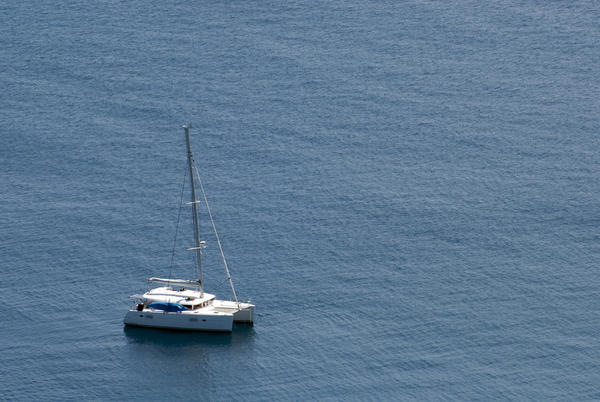 Luxury sailing catamaran moored offshore in mid ocean for a tropical vacation with copyspace