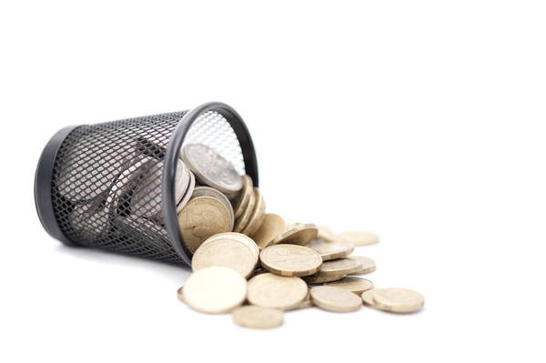 Conceptual image of golden coins in a trash bin