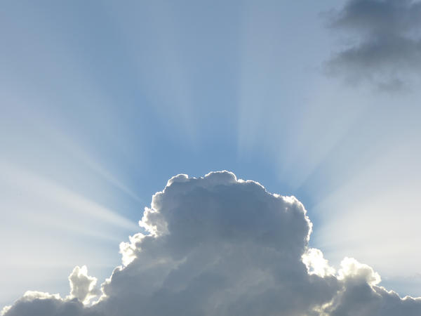 beams of light emerging from behind a cloud after a passing storm