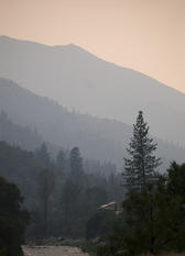 a line of hills dissappearing into a misty sunset