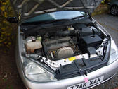 a car with the bonnet open, old rusty engine components