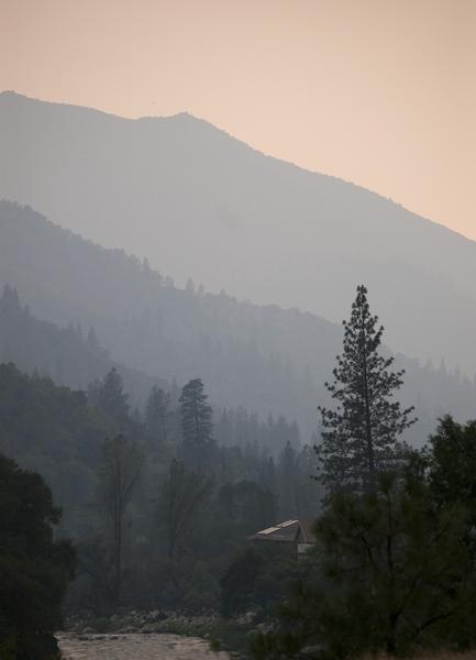 a line of hills dissappearing into a misty sunset