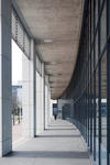 External covered passageway on a modern commercial building with a curved receding perspective in an urban environment