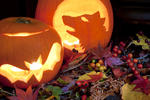 two carved halloween pumpkin lantern and a wreath of seasonal autumn berries and leaves