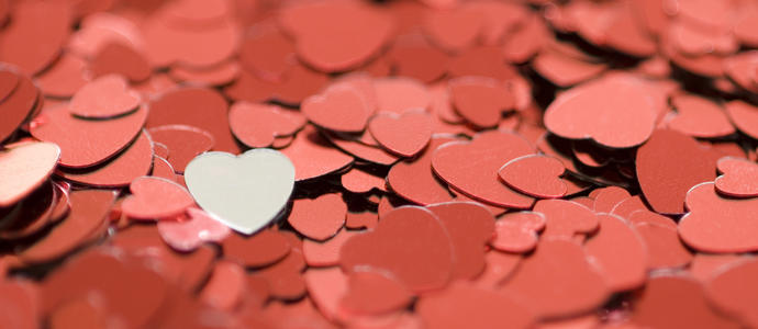 valentine concept: red metallic heart shaped confetti photographed with a narrow depth of field